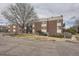 Brick apartment building featuring balconies, mature trees, and sidewalks in a quiet neighborhood at 5995 W Hampden Ave # 8C, Denver, CO 80227