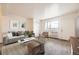Bright living room featuring a plush sofa, modern decor, and natural light streaming through a large window at 5995 W Hampden Ave # 8C, Denver, CO 80227