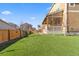Expansive backyard with a vibrant green lawn, a charming covered porch, and a classic wooden fence at 3762 White Rose Loop, Castle Rock, CO 80108