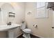 Charming powder room with a pedestal sink, stylish mirror, and classic design elements at 3762 White Rose Loop, Castle Rock, CO 80108