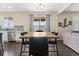 Open dining area with modern table, chairs, and stainless steel appliances in the background at 3762 White Rose Loop, Castle Rock, CO 80108