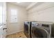 Bright laundry room featuring a modern washer and dryer and shelving, offering convenience and functionality at 3762 White Rose Loop, Castle Rock, CO 80108