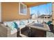 Inviting covered patio with comfortable seating area, pillow accents, and a coffee table at 3762 White Rose Loop, Castle Rock, CO 80108