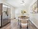 Bright dining area features a modern chandelier, table with seating for four, and stainless-steel refrigerator at 9054 Dover St, Westminster, CO 80021