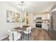 Bright, modern kitchen with stainless steel appliances, white cabinets, and a dining area with stylish art and floral arrangements at 9054 Dover St, Westminster, CO 80021