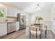 Bright kitchen featuring stainless steel appliances, white cabinets, a dining area, modern lighting, and an eye-catching patterned rug at 9054 Dover St, Westminster, CO 80021