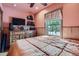 Bedroom featuring pink walls, wood trim, and dresser with TV at 5704 Ammons St, Arvada, CO 80002