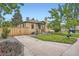 Charming brick home featuring a lush lawn, concrete driveway, and a wooden fence for added privacy at 5704 Ammons St, Arvada, CO 80002