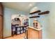 Bright kitchen with floating shelves, cabinets, and view to living area with fireplace at 5704 Ammons St, Arvada, CO 80002