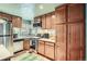 Compact kitchen equipped with stainless steel appliances, ample wooden cabinetry, and bright lighting at 5704 Ammons St, Arvada, CO 80002