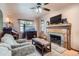 Cozy living room with a brick fireplace, ceiling fan, and comfortable furnishings at 5704 Ammons St, Arvada, CO 80002