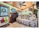 Living room featuring wood ceiling, ceiling fan, seating, and tiled floor entrance at 5704 Ammons St, Arvada, CO 80002
