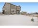 Snow-covered backyard with a wooden fence and a view of the house's back elevation at 250 Paloma Way, Elizabeth, CO 80107