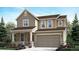 Two-story house featuring a beige exterior, stone accents, and a two-car garage at 250 Paloma Way, Elizabeth, CO 80107