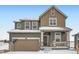 Two-story house with brown siding, a double garage, and a front porch at 250 Paloma Way, Elizabeth, CO 80107