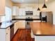 Bright kitchen featuring white cabinets, stainless steel appliances, and a functional island at 20768 Randolph Pl, Denver, CO 80249