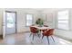 Bright dining area featuring contemporary furnishings, large windows, and a clear view to the front entry door at 4325 S Cherokee St, Englewood, CO 80110