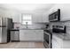 Bright kitchen with stainless steel appliances, granite countertops, and white cabinets at 4325 S Cherokee St, Englewood, CO 80110