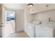 Well lit laundry room with bright white washer and dryer next to the back door at 4325 S Cherokee St, Englewood, CO 80110