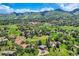 Wide aerial shot showcases homes nestled among rock formations and lush greenery in a stunning mountain community at 6451 Crestbrook Dr, Morrison, CO 80465