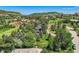 Elevated angle features a home surrounded by mature trees and lush landscaping, nestled in a scenic community at 6451 Crestbrook Dr, Morrison, CO 80465