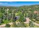 Expansive aerial view of a home nestled within lush greenery and rolling hills, offering a serene and private setting at 6451 Crestbrook Dr, Morrison, CO 80465