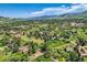 Expansive aerial view of a lush community with rolling hills and scenic mountain backdrop, showcasing a serene landscape at 6451 Crestbrook Dr, Morrison, CO 80465