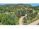 Overhead view captures a home with a pool, set amongst mature trees and green lawns in a scenic mountain community at 6451 Crestbrook Dr, Morrison, CO 80465