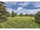Sprawling backyard with well-maintained lawn and mature trees, perfect for outdoor activities and relaxation at 6451 Crestbrook Dr, Morrison, CO 80465