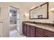 Bathroom featuring granite counters, wood cabinets, and tile surround on tub at 6451 Crestbrook Dr, Morrison, CO 80465