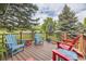 Inviting outdoor deck with colorful Adirondack chairs and scenic views of the surrounding landscape at 6451 Crestbrook Dr, Morrison, CO 80465