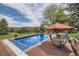 Sparkling swimming pool with patio furniture for entertaining and enjoying the outdoors in a serene setting at 6451 Crestbrook Dr, Morrison, CO 80465