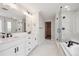 Elegant bathroom featuring double sinks, modern lighting, and a glass-enclosed shower with marble-look tile at 5549 Riverbend Ave, Firestone, CO 80504