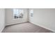 Bright bedroom featuring neutral carpet, walls, and two windows offering natural light and neighborhood views at 5549 Riverbend Ave, Firestone, CO 80504