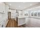 Modern kitchen with white cabinets, stainless steel appliances, and an island with sink at 5549 Riverbend Ave, Firestone, CO 80504