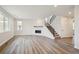 Spacious living room featuring modern fireplace, staircase, and hardwood floors at 5549 Riverbend Ave, Firestone, CO 80504