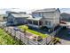 Aerial view of a large, fenced backyard with a lush lawn, garden beds, and an enclosed sunroom at 2355 Saddle Back Ct, Fort Lupton, CO 80621