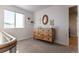 Bright bedroom with a wooden dresser, a decor mirror, and ample natural light at 2355 Saddle Back Ct, Fort Lupton, CO 80621
