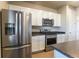 Modern kitchen featuring stainless steel appliances, white cabinets, and dark countertops at 2355 Saddle Back Ct, Fort Lupton, CO 80621