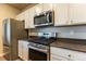 Close-up of kitchen featuring stainless steel appliances and white cabinets at 2355 Saddle Back Ct, Fort Lupton, CO 80621