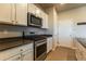 Kitchen featuring stainless steel microwave and oven, white cabinets, and pantry at 2355 Saddle Back Ct, Fort Lupton, CO 80621