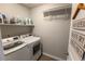 Bright laundry room with modern white washer and dryer, shelving, and stylish 'Wash-Repeat' decor at 2355 Saddle Back Ct, Fort Lupton, CO 80621