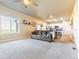 Spacious living room featuring neutral carpet, large window, and a view of the kitchen at 2355 Saddle Back Ct, Fort Lupton, CO 80621