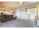 Bright open concept living room with plush carpeting, large sofa, and modern decor at 2355 Saddle Back Ct, Fort Lupton, CO 80621