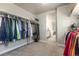 Spacious walk-in closet with ample hanging space, carpet floors and an adjacent bathroom at 2355 Saddle Back Ct, Fort Lupton, CO 80621