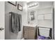 Bright bathroom featuring a wooden vanity with a round mirror and open shelving above a toilet at 1165 S Fairplay Cir # B, Aurora, CO 80012