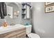 Well-lit bathroom features a modern vanity with storage and a decorative round mirror at 1165 S Fairplay Cir # B, Aurora, CO 80012