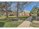 Exterior view of brick and green townhomes with mature trees and grassy lawns at 1165 S Fairplay Cir # B, Aurora, CO 80012