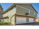 Exterior view of a two-story townhome with green siding and attached garages at 1165 S Fairplay Cir # B, Aurora, CO 80012