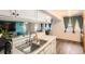 Open-concept kitchen boasts stainless steel sink, white cabinets, and a breakfast bar overlooking the dining area at 1165 S Fairplay Cir # B, Aurora, CO 80012